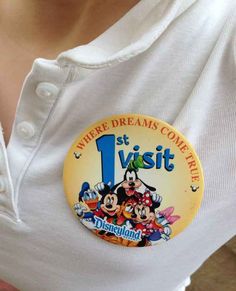 a person wearing a white shirt with a mickey mouse button on it's chest