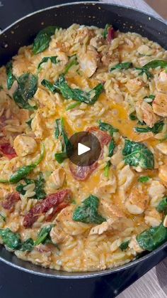 a skillet filled with pasta and spinach