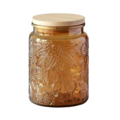 a glass jar filled with liquid sitting on top of a white table next to a wooden lid