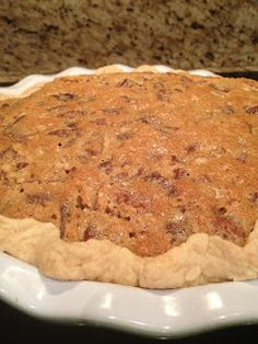 a pie sitting on top of a white plate in front of a granite countertop