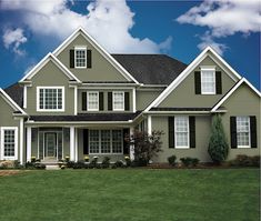 a large gray house with white trim and windows