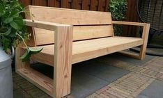 a wooden bench sitting next to a potted plant