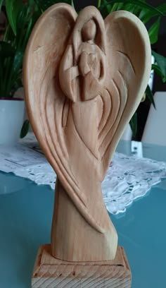 a wooden carving of an angel on a table