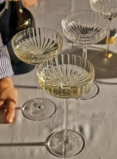 three wine glasses sitting on top of a table