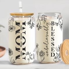 two personalized candles are next to each other on a table with a wooden lid