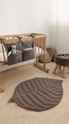 a baby's room with a crib, chair and ottoman