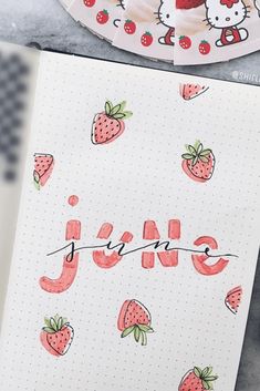 an open notebook with hello kitty stickers on it and the word june written in cursive writing