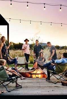 a group of people sitting around a fire pit