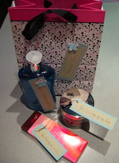 an open gift bag with two tags and some other items in it sitting on a table