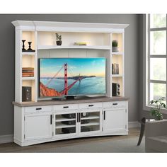 a white entertainment center with a flat screen tv on it's side and shelves