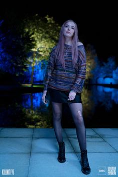 a woman standing in front of a body of water wearing tights and stockings with holes on them