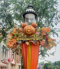 an inflatable halloween time sign with pumpkins and leaves on it's head