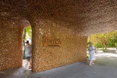 the entrance to an art museum with people walking by it and trees in the background