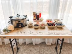 a wooden table topped with bowls of food next to a pot filled with fruit and veggies