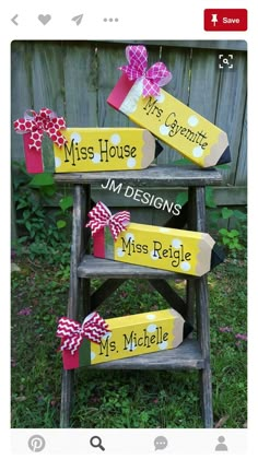 three wooden signs with bows on them sitting in the grass