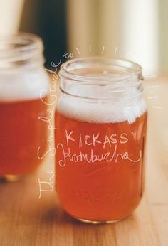 two jars filled with liquid sitting on top of a table