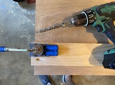 a drill is being used to cut wood with a cordless screwdriver on the table