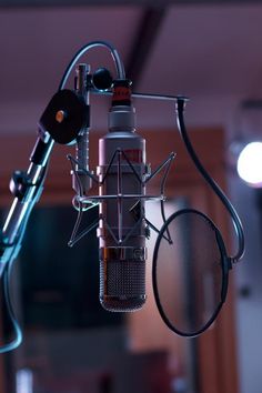 a microphone with a tennis racket hanging from it's side in a recording studio