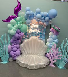 an under the sea themed birthday party with balloons and mermaid tailes, seashells and other decorations