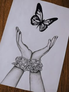 a drawing of two hands with chains and a butterfly on top of the image, in black and white