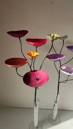 three vases with flowers in them sitting on a table