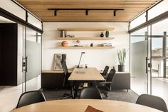 an empty conference room with black chairs and wooden tables