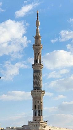 a tall white tower with a clock on it's side against a blue sky