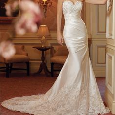 a woman in a white wedding dress posing for the camera with her hand on her hip