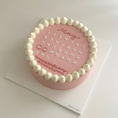 a pink birthday cake with white frosting on top