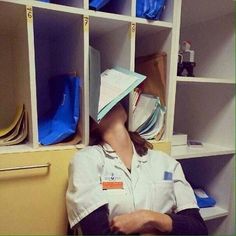 a woman with a paper hat on her head sitting in front of a bookcase