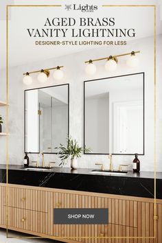 a bathroom vanity with two mirrors and lights on it, in front of a white wall