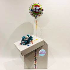 a birthday balloon sitting on top of a box