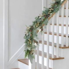 christmas garland with pine cones and berries on the bannister rail at the bottom of stairs