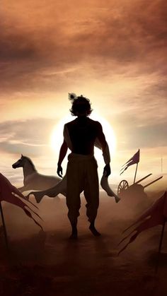 the silhouette of a man standing in front of two horses with flags behind him and an orange sky