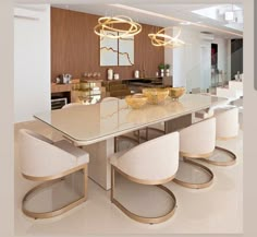 a dining room table with white chairs and gold trim around the edges, in front of an open kitchen area