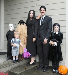 a family dressed up for halloween standing in front of a house