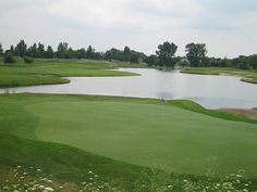 a golf course with water in the background