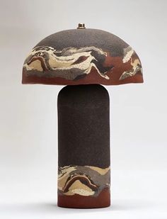 a mushroom shaped table lamp is shown in brown and beige marbled material with a black base