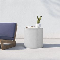 a chair and table sitting next to each other in front of a white stucco wall