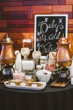 a table topped with lots of different types of candy and candies next to a chalkboard