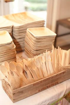 wooden spoons are stacked in a box on a table