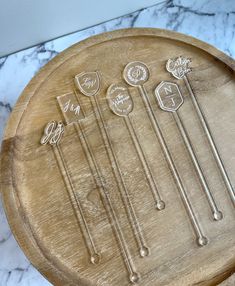 a wooden tray topped with lots of different types of utensils on top of a marble counter