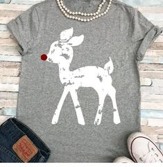 a t - shirt with a deer on it next to some shoes and pearls necklace