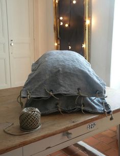 a large blue pillow sitting on top of a wooden table in front of a mirror