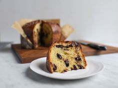 a piece of cake sitting on top of a white plate next to a loaf of bread