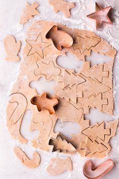 some cookies are laying on the table with one cut out and two shaped like stars