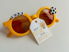 a pair of yellow sunglasses with a tag attached to the lenses that say, you're future bright