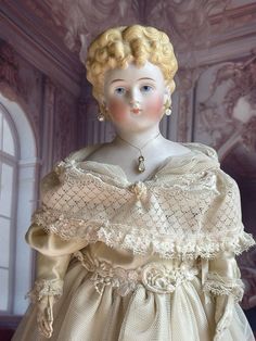 a white doll with blonde hair wearing a dress