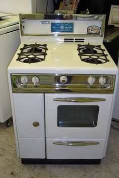 an old fashioned white stove with two burners and one oven door is on the floor