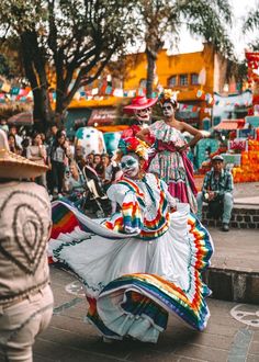 people in colorful costumes are dancing on the street